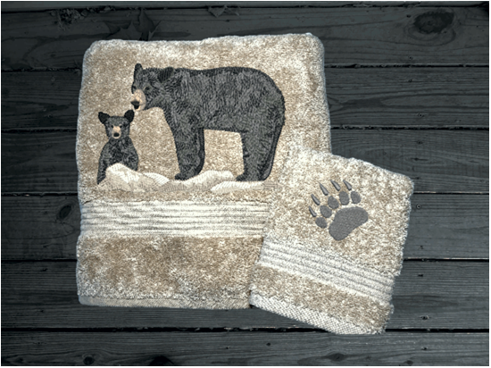 Beige bath towel and washcloth, embroidered bear design the perfect design for the outdoor living family. This Luxury theme towel set of 3 towels 1 bath towel 27" x 50", 1 hand towel 16" x 27", 1 wash cloth 13" x 13". You can personalize the towel set with a name and name on the washcloth or just designs. Borgmanns Creations 