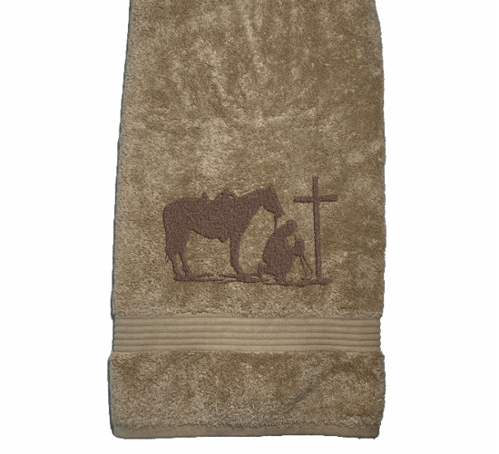 Beige bath towel , embroidered cowboy praying design, the perfect design for that farmhouse decor. This towel set has 3 towels 1 bath towel 27" x 55", 1 hand towel 16" x 27", 1 wash cloth 13" x 13". You can personalize the towel set with a name and an initial on the wash cloth - Borgmanns Creations