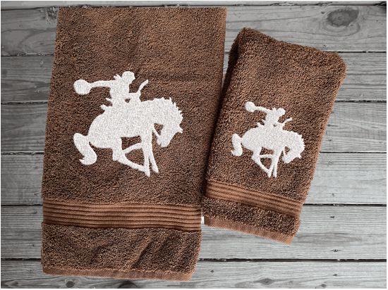 Brown  bath towel and hand towel high quality luxury Turkish Towels durable soft and absorbent, finished edges with a decorative band. Set has 1 bath towel, 1 hand towel, 1 washcloth. Embroidered with a custom design of a bronc rider. You can personalize the towel set with a name and an initial on the washcloth or just the designs. These luxury towels will make a wonderful hostess towel, wedding gift, housewarming gift, or for your own bathroom decor. Borgmanns Creations - 6