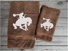 Load image into Gallery viewer, Brown  bath towel and hand towel high quality luxury Turkish Towels durable soft and absorbent, finished edges with a decorative band. Set has 1 bath towel, 1 hand towel, 1 washcloth. Embroidered with a custom design of a bronc rider. You can personalize the towel set with a name and an initial on the washcloth or just the designs. These luxury towels will make a wonderful hostess towel, wedding gift, housewarming gift, or for your own bathroom decor. Borgmanns Creations - 6
