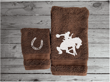 Load image into Gallery viewer, Brown  hand towel and washcloth high quality luxury Turkish Towels durable soft and absorbent, finished edges with a decorative band. Set has 1 bath towel, 1 hand towel, 1 washcloth. Embroidered with a custom design of a bronc rider. You can personalize the towel set with a name and an initial on the washcloth or just the designs. These luxury towels will make a wonderful hostess towel, wedding gift, housewarming gift, or for your own bathroom decor. Borgmanns Creations - 8
