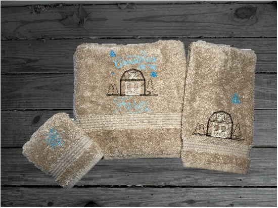 Beige bath towel set, or individual towels embroidered design of a barn at Christmas time is perfect for for that farmhouse decor. This Luxury soft and absorbent bathroom towel set of 3 towels 1 bath towel 27" x 55", 1 hand towel 16" x27", 1 wash cloth 13" x 13". Housewarming, best friend, or family gift. Borgmanns Creations