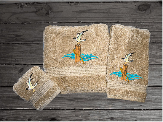 High Quality Luxury Turkish Towels durable soft and absorbent, finished edges with a decorative band. Set has 1 bath towel 27" x 50", 1 hand towel 16" x 27", 1 washcloth 13" x 13". Embroidered with a custom sea gull on a post design. You can personalize the towel set with a name and an initial on the washcloth or just the designs. These luxury towels will make a wonderful wedding gift, housewarming gift, or for your own bathroom decor. Borgmanns Cretions