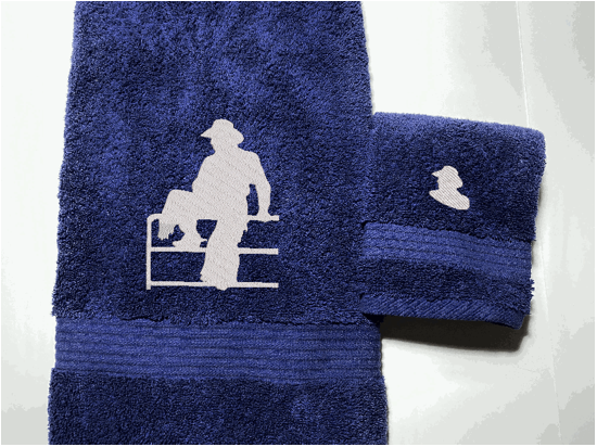 High Quality Luxury Blue Turkish bath towel and washcloth durable soft and absorbent, finished edges with a decorative band. Set has 1 bath towel 27" x 50", 1 hand towel 16" x 27", 1 washcloth 13" x 13". Embroidered with a custom design of acowboy on a fence. You can personalize the bath towel with a name and an initial on the washcloth or just the designs. These luxury towels will make a wonderful hostess towel, wedding gift, housewarming gift, or for your own bathroom decor. Borgmanns Creations