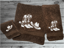 Load image into Gallery viewer, Brown bath towel set or individual towels, cowboy hat and boots is the perfect design for that farmhouse decor. This Luxury western theme towel set 3 towels 1 bath towel 27&quot;x55&quot;, 1 hand towel 15&quot;x28&quot;, 1 wash cloth 13&quot; x 13&quot;. You can personalize the towel set with a name and an initial on the wash cloth or just the designs. Borgmanns Creations 2
