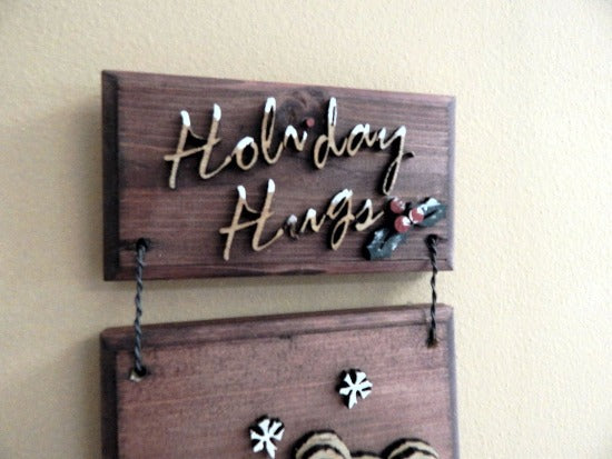 Holiday Hugs wall hanging - laser cut lauan wood layered - glued to beveled wood with mahogany stain - 2 pieces hung together with wire - painted with acrylic paint - Borgmanns Creations