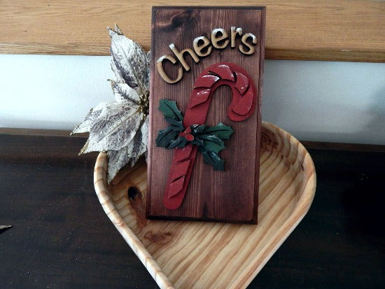 Holiday cheers candy cane layered wood decoration - laser cut luan wood and glued to the base of 1 inch beveled edge wood with mahogany stain - painted with acrylic paint - Hanging hook on back for easy hanging - Borgmanns Creations