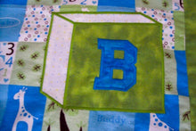 Load image into Gallery viewer, Baby Blanket, size is 38&quot; x 54&quot; embroidered applique for a crib cover, stroller blanket, made of all felt. The letters BABY are appliqued in Blue and Pink and embroidered as a block, on material design of numbers and giraffes in squares of white, yellow and blue with a green border. Backing of blue with poke a dots - Borgmanns Creations 

