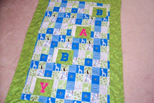 Load image into Gallery viewer, Baby Blanket, size is 38&quot; x 54&quot; embroidered applique for a crib cover, stroller blanket, made of all felt. The letters BABY are appliqued in Blue and Pink and embroidered as a block, on material design of numbers and giraffes in squares of white, yellow and blue with a green border. Backing of blue with poke a dots - Borgmanns Creations - 1
