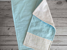 Load image into Gallery viewer, This bib and 2 burp cloths -baby blue color - one burp cloth has decorative strip of material across the end, blue and yellow dots on white background. Made of flannel top and terry cloth backing bib 9&quot; from neck to bottom- 8&quot; wide with sticky fasteners, burp cloth is 16&quot; x 8&quot;  - Borgmanns Creations -
