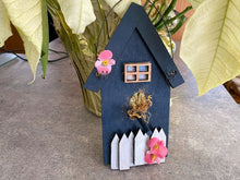 Load image into Gallery viewer, Single birdhouse, laser cut, layered wood white picket fence, blue acrylic paint, flowers, hung by wire, 8 1/2&quot; H x 5 1/2&quot; W x 1 1/2. D. A gift for the bird lover to decorate their home. This birdhouse wall hanging is a unique house warming gift or birthday gift - Borgmanns Creations 
