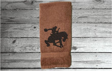 Load image into Gallery viewer, Brown Bath hand towel - silhouette bronc and rider - western rodeo ranch decor - work towel - horse lover gift - kitchen, bath or bar decor - home decor - birthday gift for him - Borgmanns Creations
