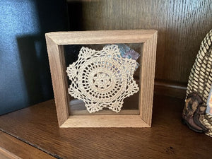 Crochet doily -  one of a kind wall hanging, or it can stand alone on any side -  wonderful gift country farmhouse decor - bedroom decor ideas for your home or a special gift - doily is vintage star pattern between 2 pieces of acrylic and framed in wood-  a piece of material to complement the doily - 7 1/8" H x 7 1/8" W x 1 1/4" D- Borgmanns Creations - 1