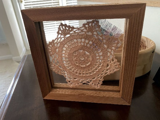 Crochet doily -  one of a kind wall hanging, or it can stand alone on any side -  wonderful gift country farmhouse decor - bedroom decor ideas for your home or a special gift - doily is vintage star pattern between 2 pieces of acrylic and framed in wood-  a piece of material to complement the doily - 7 1/8" H x 7 1/8" W x 1 1/4" D- Borgmanns Creations - 3