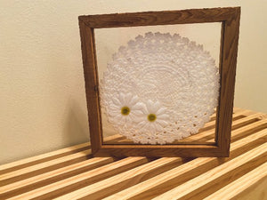 Crochet doily art one of a kind - white doily with 2 white flowers with green centers - wall hanging, or it can stand alone on any side - wonderful gift for the country farmhouse decor - bedroom decor ideas - doily is set between 2 pieces of acrylic and framed in wood. 10" H x 10" W x 1 1/4" D - Borgmanns Creations - 1