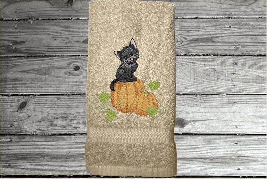 Beige hand towel, beautiful design of a cat sitting on a pumpkin, decorative towel for the bathroom or kitchen to brighten up your Halloween decor. You can personalize it for a gift to a friend or family member. The terry towel, 16" x 27", is soft and absorbent for any home decor - Borgmanns Creations - 5