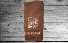 Load image into Gallery viewer, Brown hand towel western theme, embroidered wagon and horse head on a cotton terry towel, soft and absorbent, 16&quot; x 27&quot;, the perfect western cowboy design for your gusts to enjoy while at your ranch of home, personalized home decor - Borgmanns Creations 
