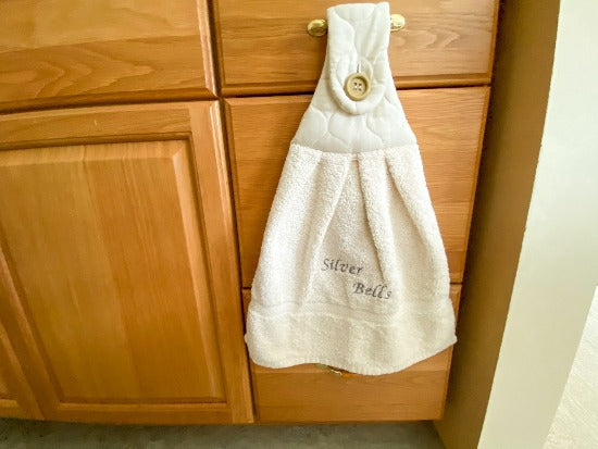 Beige hanging towel - perfect Christmas gift for mom with embroidered words Silver Bells for her kitchen decor - It can also be hooked over a bathroom cabinet handle - home decor premium terry towel is 16" wide - 21" long - Borgmanns Creations - 1