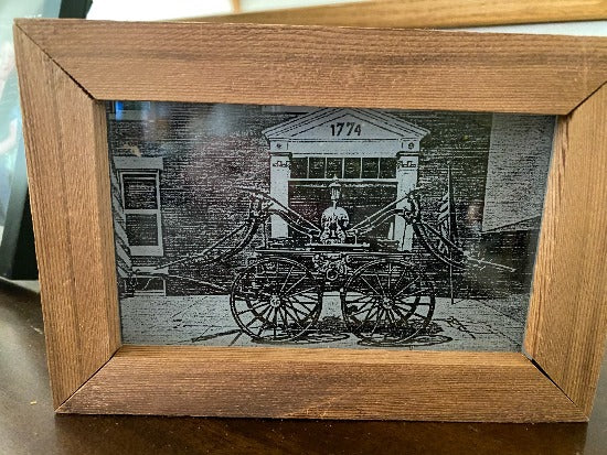 Laser engraved etching with black acrylic backing   old time firehouse and wagon pump - great gift for a fire fighter, dad or husband -  birthday present, fathers day gift, special occasion etc. - 1/2 inch thick acrylic, 6 1/2 inch x 4 1/2 inch - framed in wood, free standing - Borgmanns Creations - 1