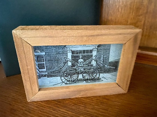 Laser engraved etching with black acrylic backing   old time firehouse and wagon pump - great gift for a fire fighter, dad or husband -  birthday present, fathers day gift, special occasion etc. - 1/2 inch thick acrylic, 6 1/2 inch x 4 1/2 inch - framed in wood, free standing - Borgmanns Creations - 3