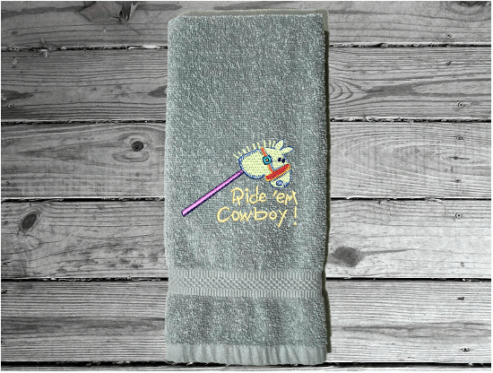 Gray hand towel 16" x 27" embroiderred stick horse with saying ride'em cowboy. You can personalize it with a name for a baby shower. Borgmanns Creations - 6