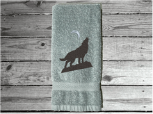Load image into Gallery viewer, Gray wolf hand towel, beautiful design of a howling wolf under the moon, embroidered on a terry towel,  soft and absorbent, 16&quot; x 27&quot;, a home decor addition for a farmhouse bathroom, kitchen for guest bath - Borgmanns Creations 
