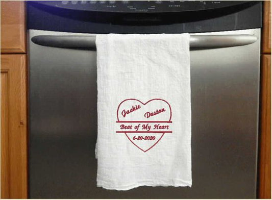 Tea towel flour sack, embroidered names and date, inside of a heart, with a ribbon across it saying" beat of my heart", 29 inches x 29 inches, gift for various occasions through out the year. Wedding, Anniversary, Mother's Day, Father's Day, Valentines Day. Kitchen dish towel can display the couples special day - Borgmanns Creations 
