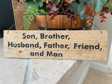 Load image into Gallery viewer, Rustic sign upcycled cedar fence panel with the saying &quot; Brother, Husband Father Friend and Man&quot; hand painted, 4&quot; H x 13 3/4&quot; W x 1/2&quot; D, hung by wire, would be a unique one of a kind housewarming gift or unique farmhouse decor. The natural wood color will go with any room - Borgmanns Creations 
