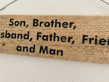 Load image into Gallery viewer, Rustic sign upcycled cedar fence panel with the saying &quot; Brother, Husband Father Friend and Man&quot; hand painted, 4&quot; H x 13 3/4&quot; W x 1/2&quot; D, hung by wire, would be a unique one of a kind housewarming gift or unique farmhouse decor. The natural wood color will go with any room - Borgmanns Creations 
