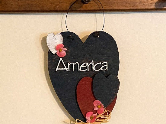 Holiday decor "America" wall art will add to your home decor - laser cut Luan wood painted with acrylic paint glued together, flowers and raffia to complete the wall art - home decor for kitchen, living room, den or hallway - perfect summer and 4th of July decoration, Valentines Day, Memorial Day, Labor Day, etc.  - Borgmanns Creations - 1
