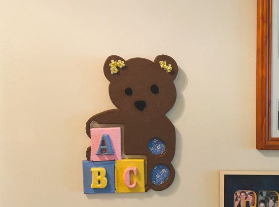 Wood wall art wall hanging, 1/2" MDF board, layered wood, hand painted brown, with wire, pompom balls, flowers and hanging hook on the back, 14" H x 10" W x 1/2" D, this wood sculpture of a brown teddy bear would be a great baby shower gift for the farmhouse decor or even leaning against a wall at floor level - Borgmanns Creations