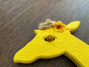 Yellow giraffe stone like wall decor with wire details, layered ears, hand painted, 21" H x15" W x1/2" D, material - green and white for spots, twine, flowers and hanging hooks on back. Just the gift for the giraffe collector. Makes a wonderful baby shower gift for the nursery - Borgmanns Creations