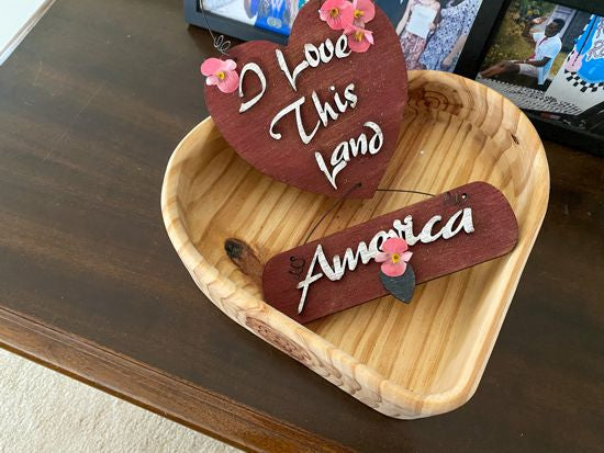 Wood wall hanging " I love this Land America", laser cut Luan wood, wire attaches top heart to second piece, letters cut from luan wood, acrylic paint, glued together, flowers to complete the wall art, .12" x 7" including wire hanger, a great home decor gift for a veteran for his den or study - Borgmann Creations 
